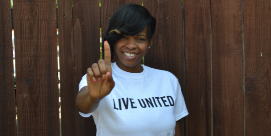 Smiling black woman wearing a LIVE UNITED t-shirt
