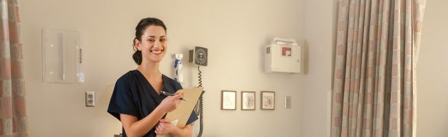 Smiling CNA standing in a patient room