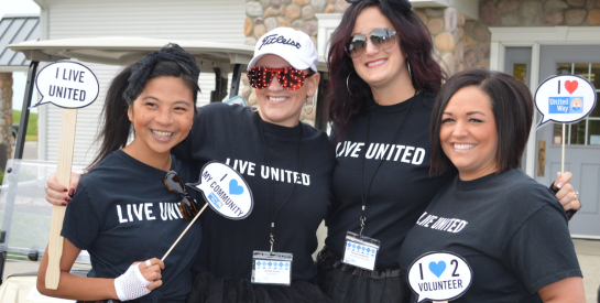 Smiling women wearing LIVE UNITED t-shirts at the United Fore Kids Golf Scramble
