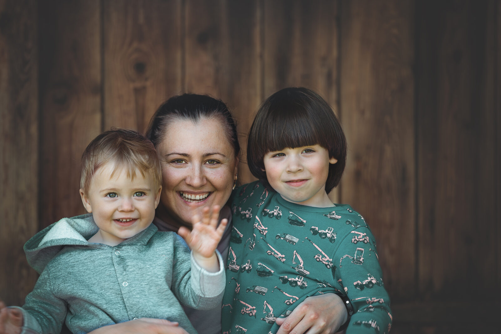 Mother,and,two,sons,portrait,on,wooden,background